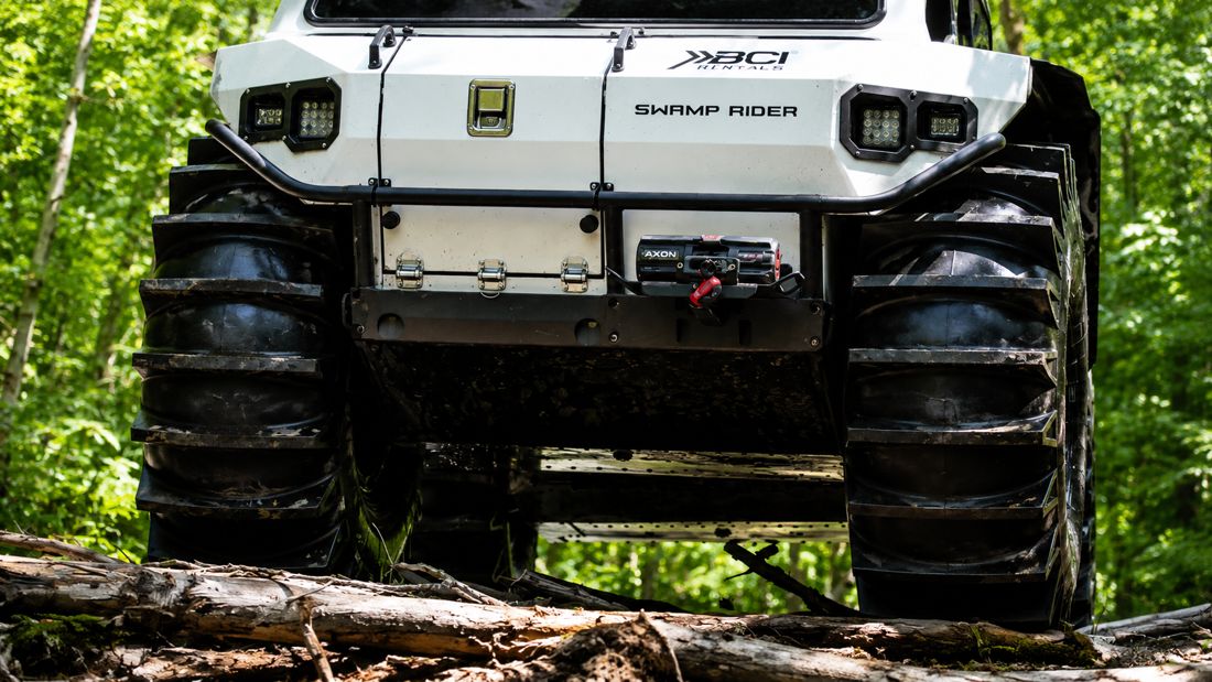 Underside skid plates and paddle tires of a Swamp Rider crossing rough right-of-way terrain